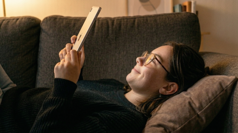Woman relaxing on a couch while looking at her phone